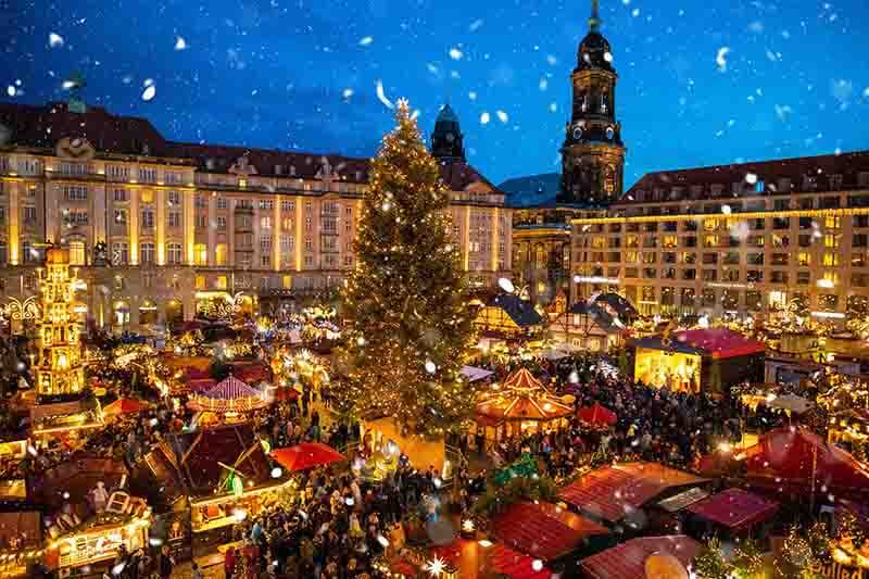 European style Christmas market, with vendor stalls, rides, games, and plenty of lights and snow.