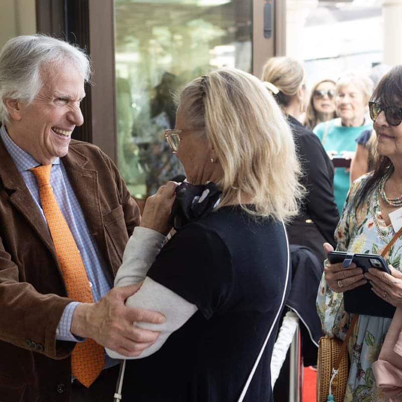 Henry Winkler posing for photos with residents and guests at the Red Carpet Speaker event.